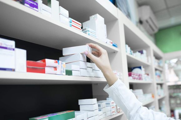 uir7ej closeup view pharmacist hand taking medicine box from shelf drug store 20231109230427